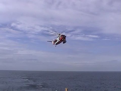 British coastguard helicopter flying toward ferry
