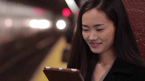 Young Asian woman using tablet PC reading ebook