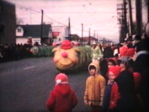 WINNIPEG, CANADA - CIRCA 1964: Performers underneath giant worm costumes and floats march though downtown Winnipeg during the annual Santa Claus parade circa 1964 in Winnipeg, Manitoba, Canada.