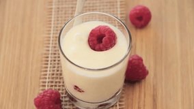 Ripe raspberry in glass with yogurt, turn, video