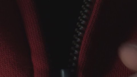 Young Man Pulling Up A Zipper On A Red Shirt Close Up-Shot