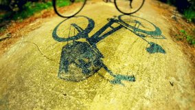 Bicycle shadow and chalk color drawing process around it on concrete. Time lapse. 