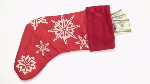Generous Santa stuffs Christmas stocking with hundred dollar bills