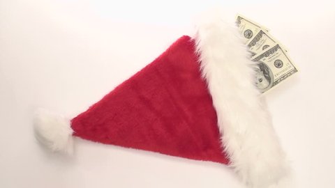 Santa Claus stuffs his hat with hundred dollar bills