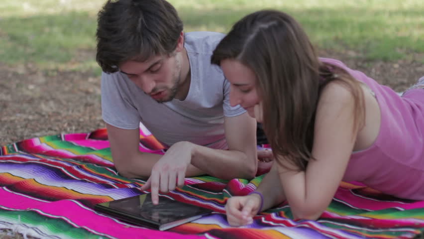 Tablet - Happy young couple with tablet computer in the park - watching photo