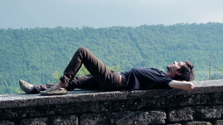 happy boy relaxes lying on a wall - rest - into the wild