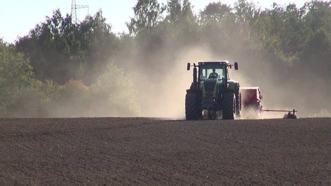 tractor seeding grain crop on farm field

