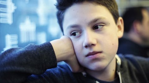 Sad, pensive young teenager riding train, subway
