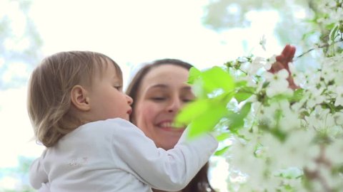 Mother and Baby having fun Outdoors. Playing Together in Green Spring Park. Mom and Child in orchard. Happy Family Smiling. Beautiful family in spring park enjoying nature. 1920x1080p slow motion