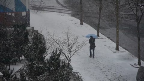 a man take umbrella walking on winter sidewalk,snowstorm. gh2_06024