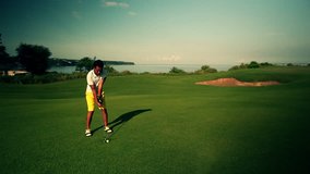 Amazing golf course at dawn with a golfer teeing off with ocean view in the background