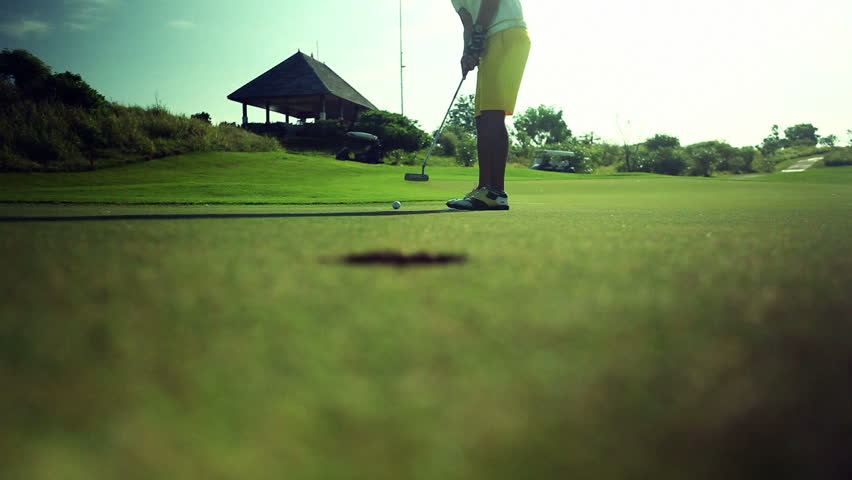 Golf player taking his putt on a beautiful green golf course