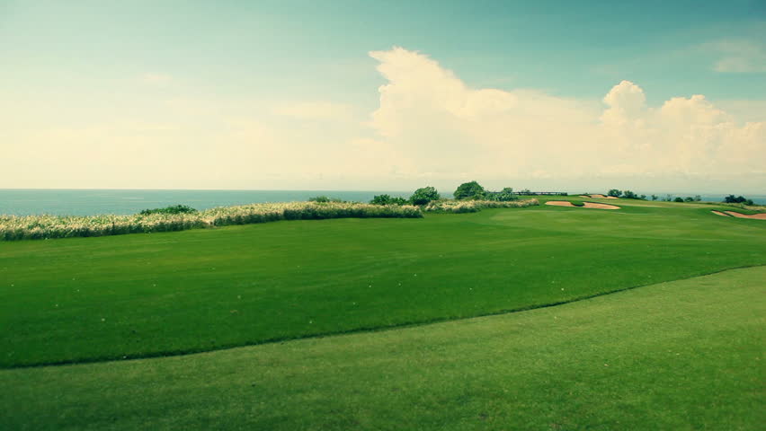 Wide angle panorama of a beautiful golf course with ocean view in the background