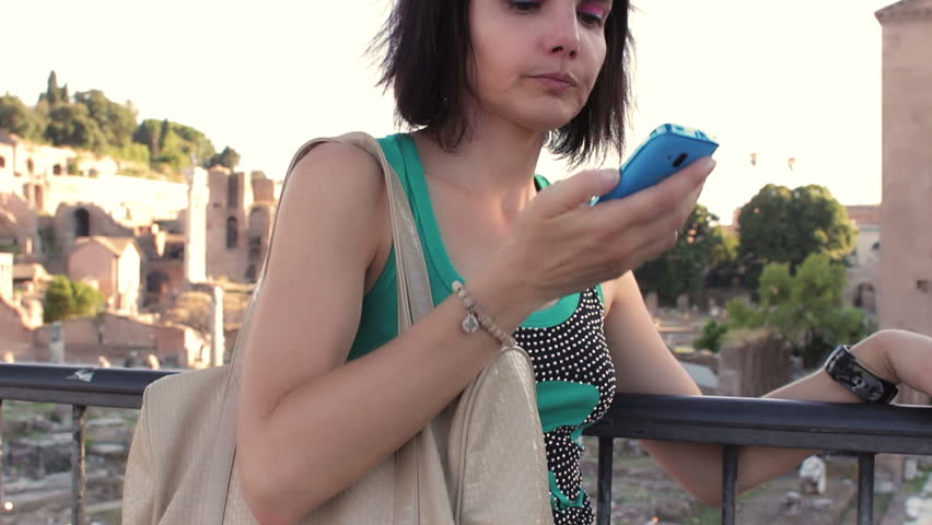 woman receives a call on his cell phone , near roman forum - steadycam