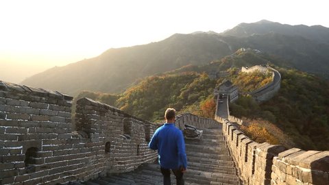 Great Wall of China male walking on the historic fortified wall between watch towers Mutianyu nr Beijing, China, Asia