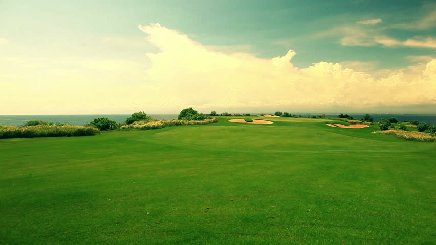 Wide angle panorama of a beautiful golf course with ocean view in the background