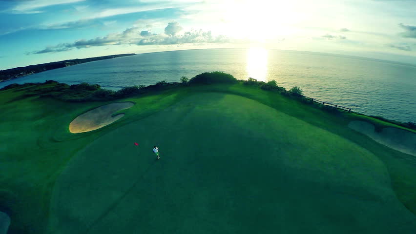 Aerial shot of a beautiful golf course with indian ocean and amazing sunset in