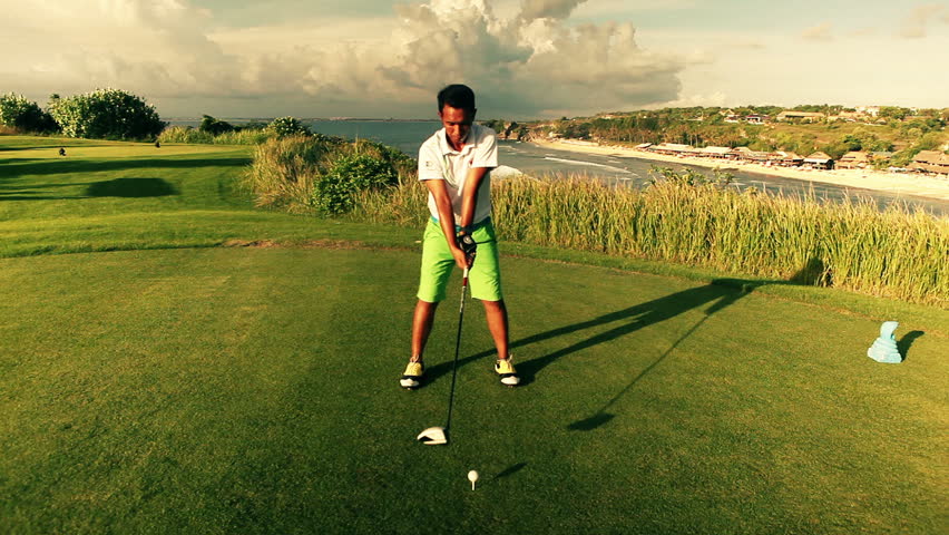 Amazing golf course at dawn with a golfer teeing off with ocean view in the