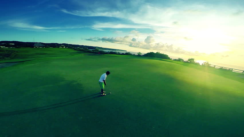 Aerial shot of a beautiful golf course with golfer making his putt surrounded by
