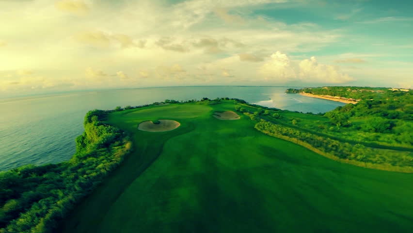 Aerial shot of a beautiful golf course surrounded by the crystal clear indian