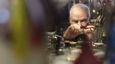 Watchmaker checks the operation of a old clock