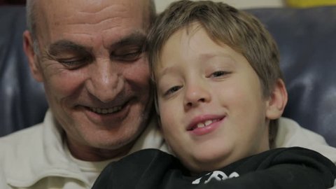 grandfather and grandson laughing and looking at the camera - old man and child