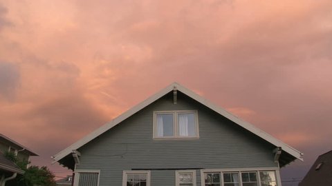 Full sunset over house with lights turning on and off as night falls.