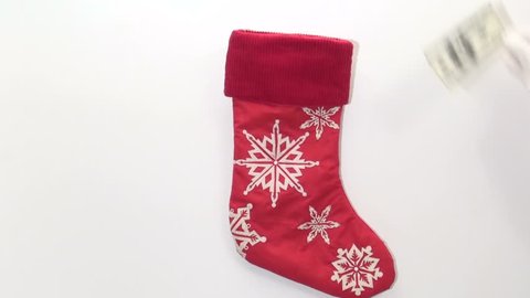 Generous Santa puts cash in stocking isolated on white background