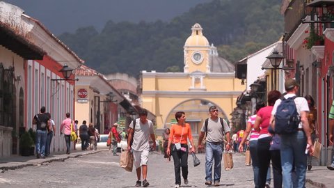 ANTIGUA GUATEMALA,GUATEMALA,2012:Tourist industry.Tourists on the streets of the colonial small town.Perspective of cobbled streets with colonial architecture style  buildings in a picturesque valley.