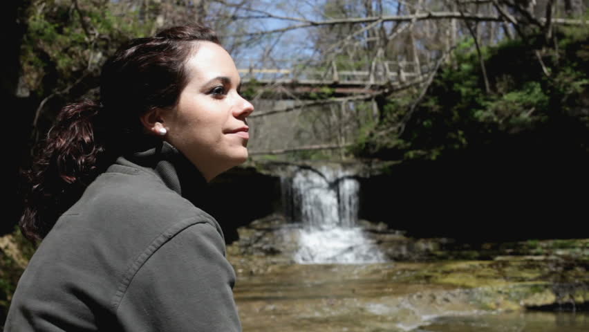 Girl enjoying nature with waterfall