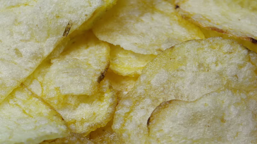 Fresh potato chips. Close up shot of rotating potato chips.