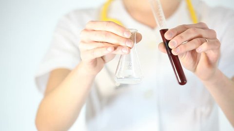woman scientist holds two flasks in her hand