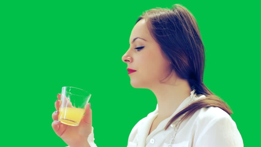 A attractive young woman drinks and smiling at the camera - green screen