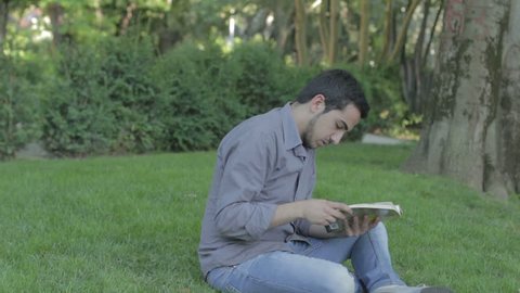 boy reads a book in the park but is interrupted by prank of a friend