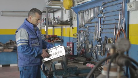 the work of Auto mechanic - Auto mechanic repairing a motor - dolly