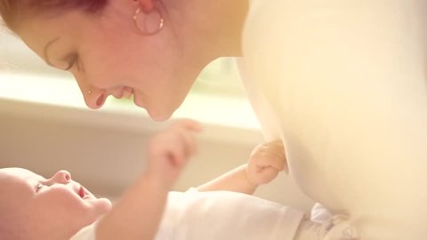 Mother and her Newborn Baby. Happy Mother and Baby kissing and hugging. Resting together. Maternity concept. Parenthood. Motherhood Beautiful Happy Family Footage. Full HD 1080 Slow Motion 240 fps