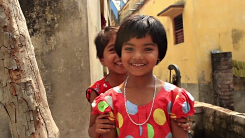 Two cute and sweet sisters playfully pose for the camera. HD 1920 by 1080. Filmed in Navadvipa, Nadia, Bengal, India.