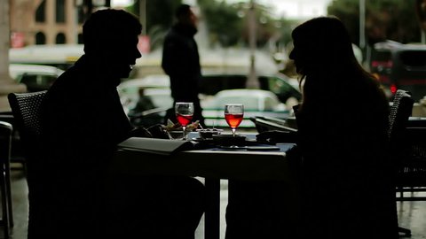 Silhouette - Young business man and woman toasting with red drink