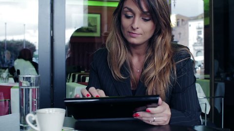 Young businesswoman using tablet computer in cafe