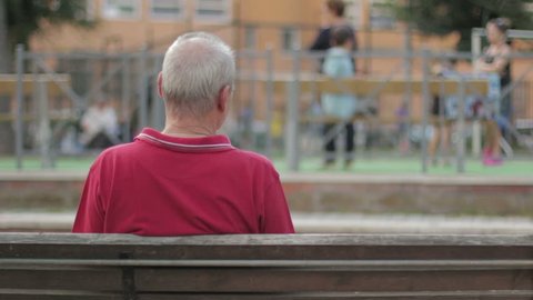 Elderly man's on a bench, backfacing. In park