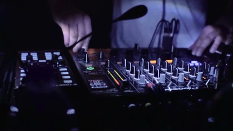 A DJ plays with the mixer in disco