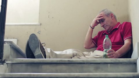 Old man drinking in despair