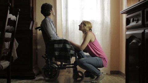 wife holding hands and caresses her depressed husband disabled