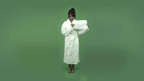 indian woman in bathrobe isolated on green upset with blank sign