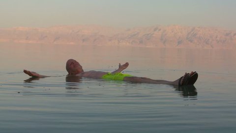 DEAD SEA CIRCA 2013 - A man floats on his back in the Dead Sea of Jordan or Israel.