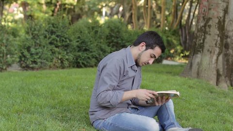 boy reads a book in the park but is interrupted by prank of a friend