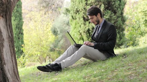 Young business man sitting using tablet