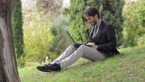 Businessman in a park holding a touch screen device