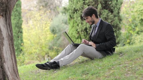 Business man using digital tablet at park