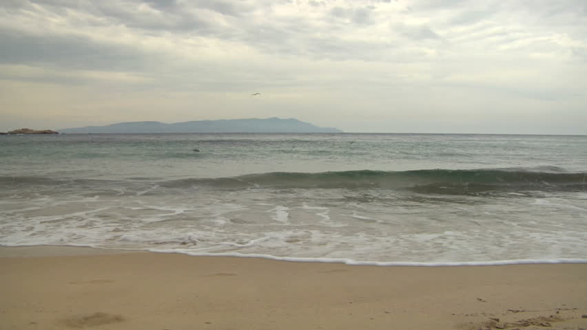 Mediterranean beach with breaking wave (slow motion)